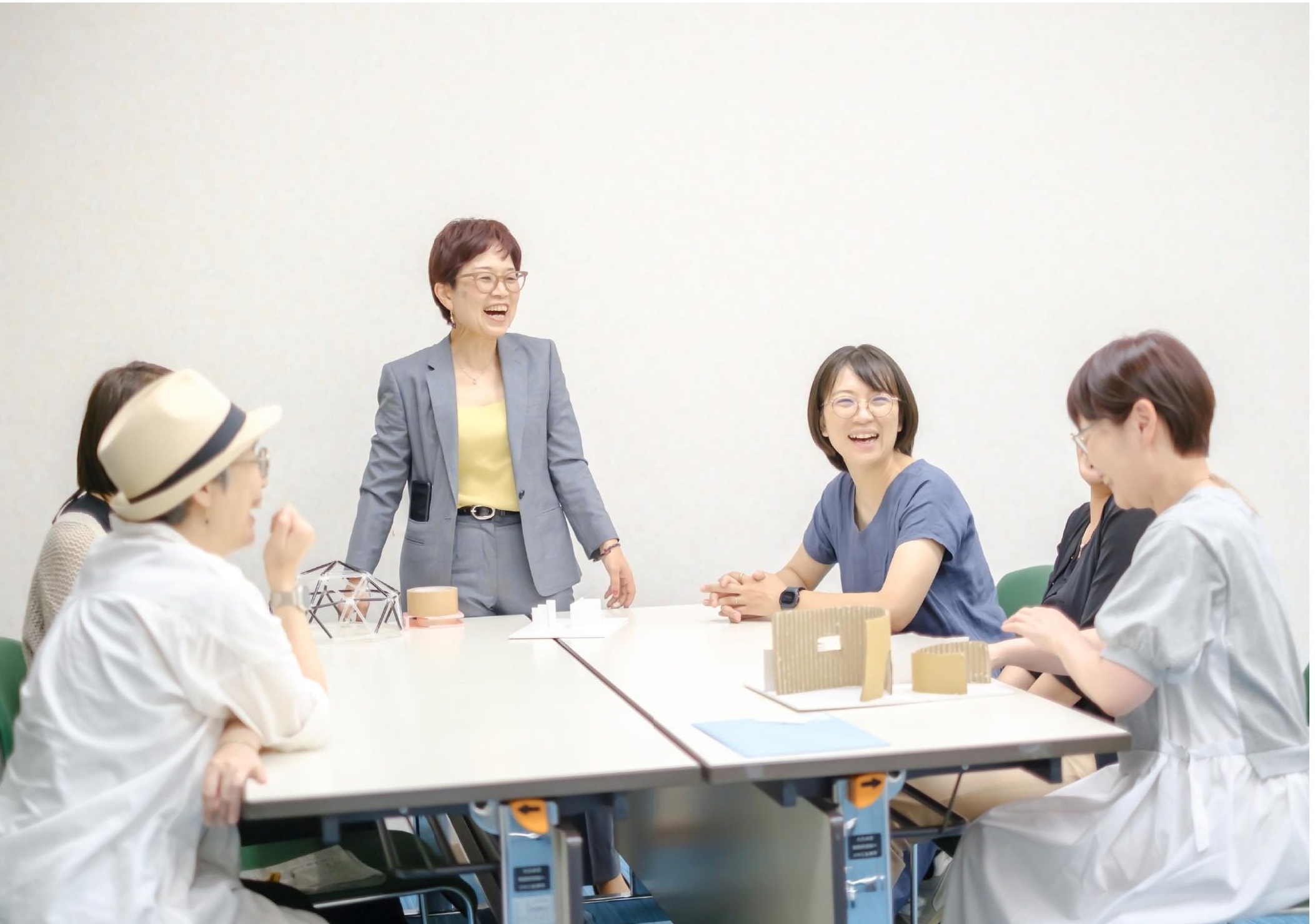 レーザーカットの木製模型を囲んで話す大人たち